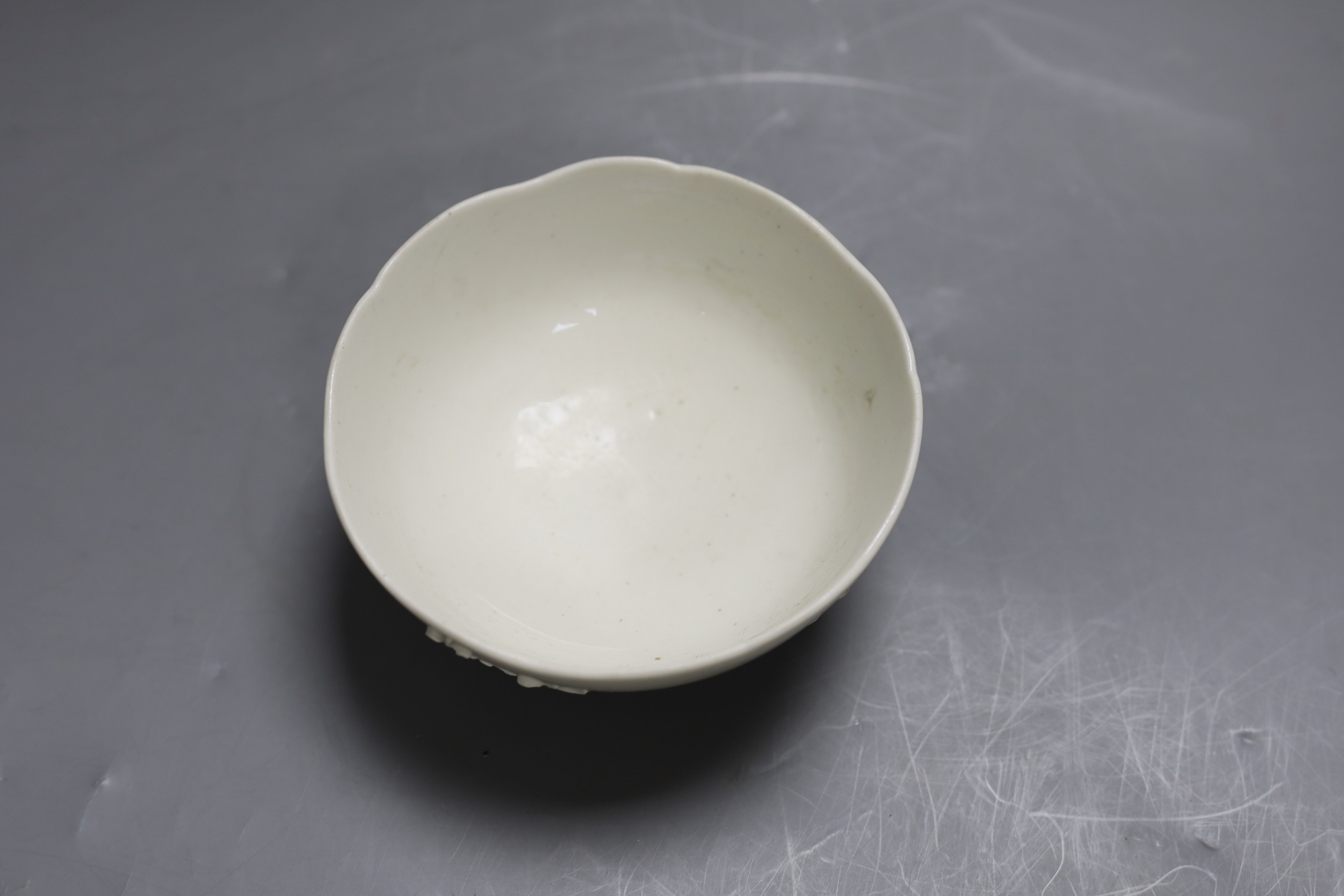 An 18th century Bow white glazed ‘prunus’ bowl, and a Bow octagonal plate, with floral design, 21cm diameter